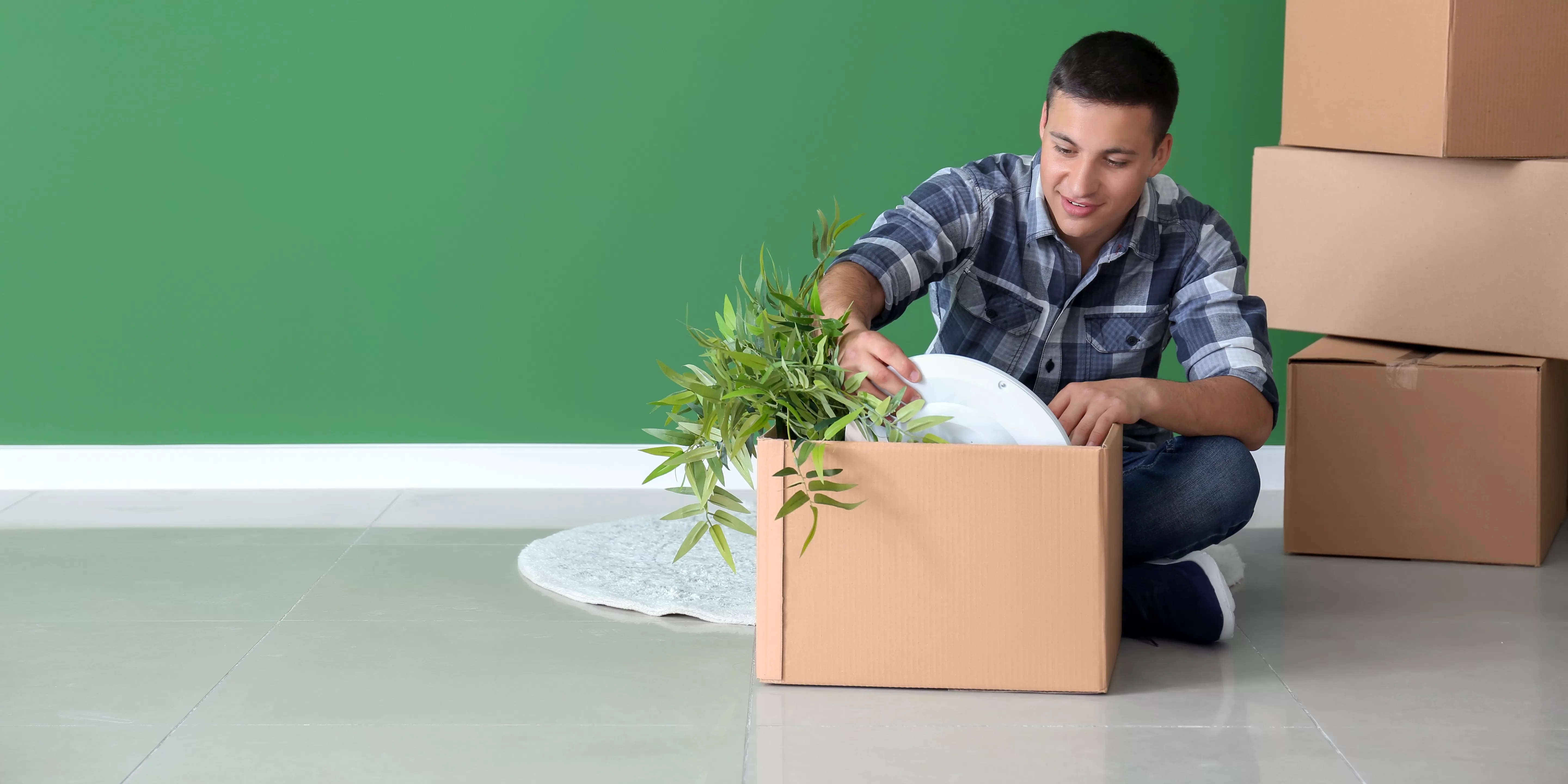 Person sitting on floor unpacking a box